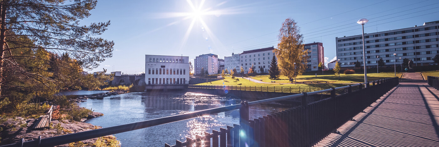 Auringonpaisteessa Loiste lämmön voimalaitos joen suunnalta kuvattuna